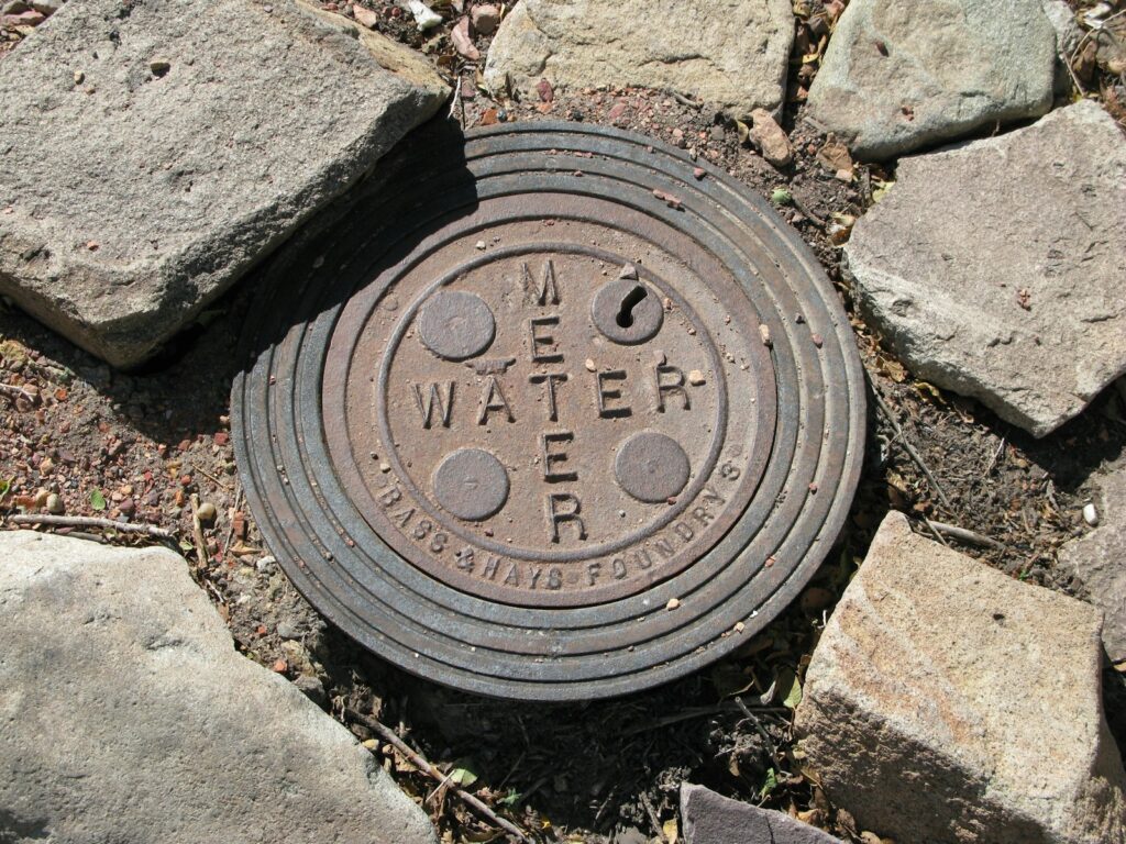 a manhole cover in the ground surrounded by rocks