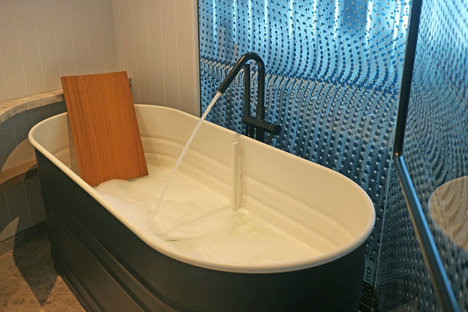 a white bath tub sitting next to a walk in shower Drain Unclogging