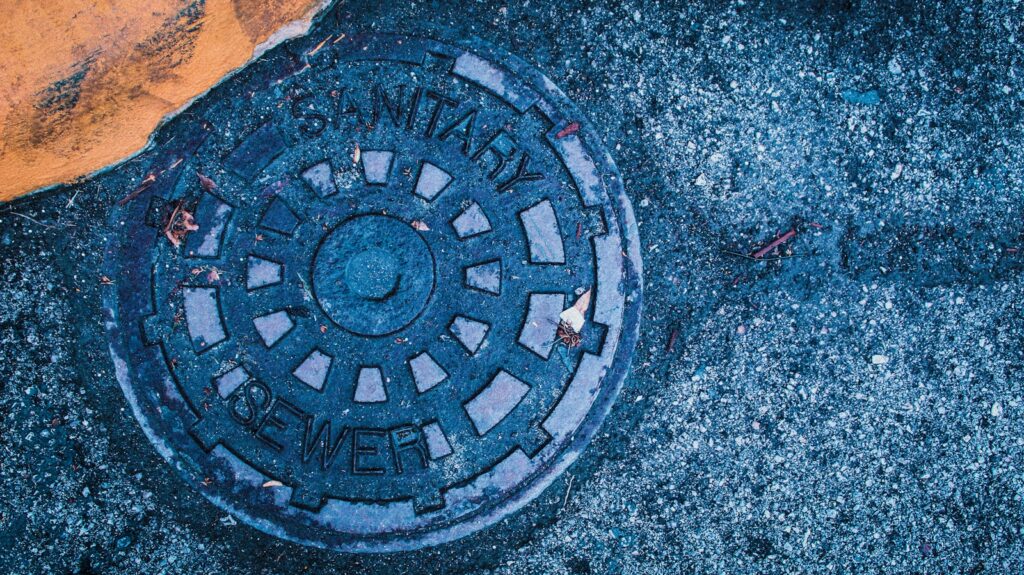 a manhole cover sitting on the side of a road