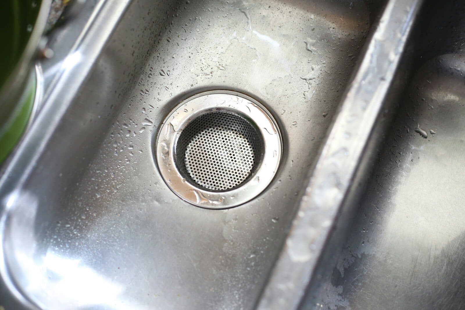 Photo by Giorgio Trovato a stainless steel sink with a strainer in it Hydro Jetting: The Powerful Solution for Stubborn Clogs