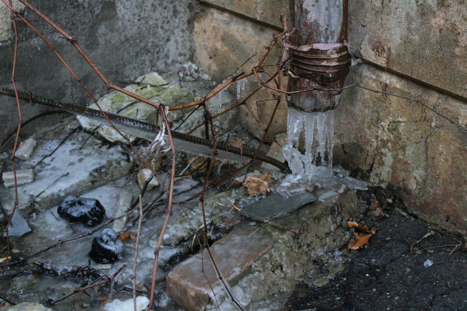 Photo by Nadiia Ganzhyi a fire hydrant next to a wall with ice on it Preventing Plumbing Frozen Pipes: How Bowie & Alexandria Homes Can Avoid Winter Disasters