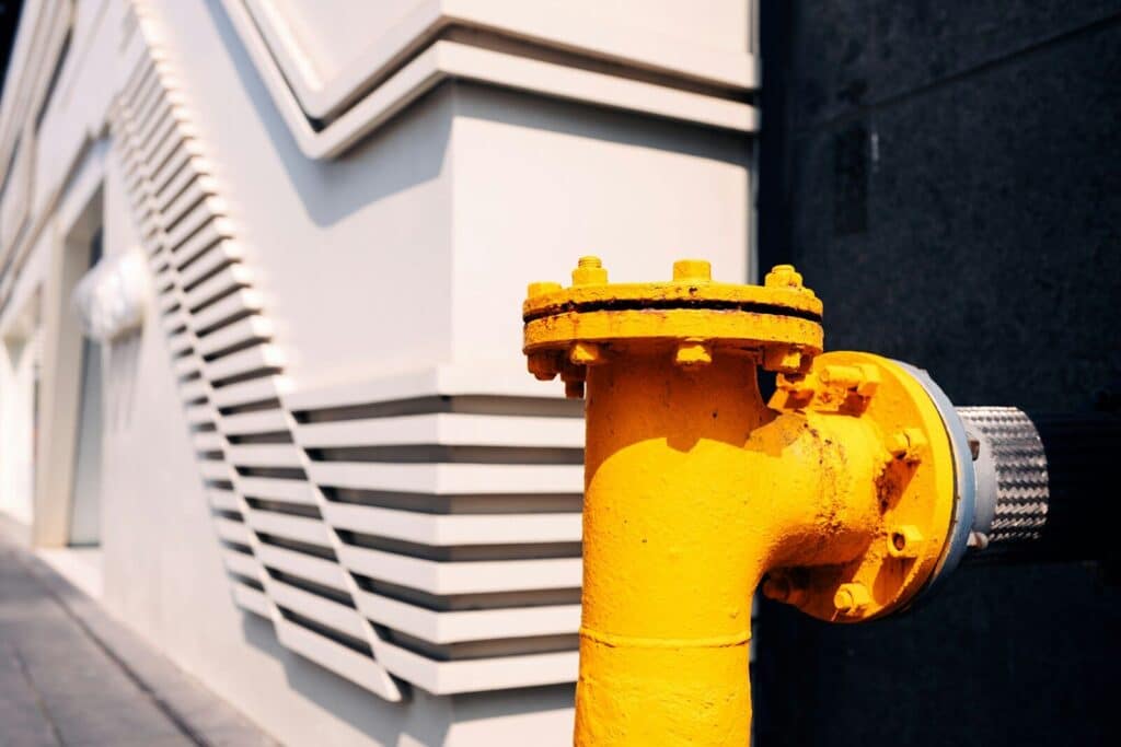 A bright yellow pipe against a building