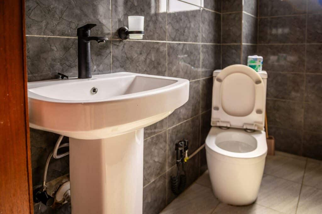 A modern bathroom with a white sink and toilet.